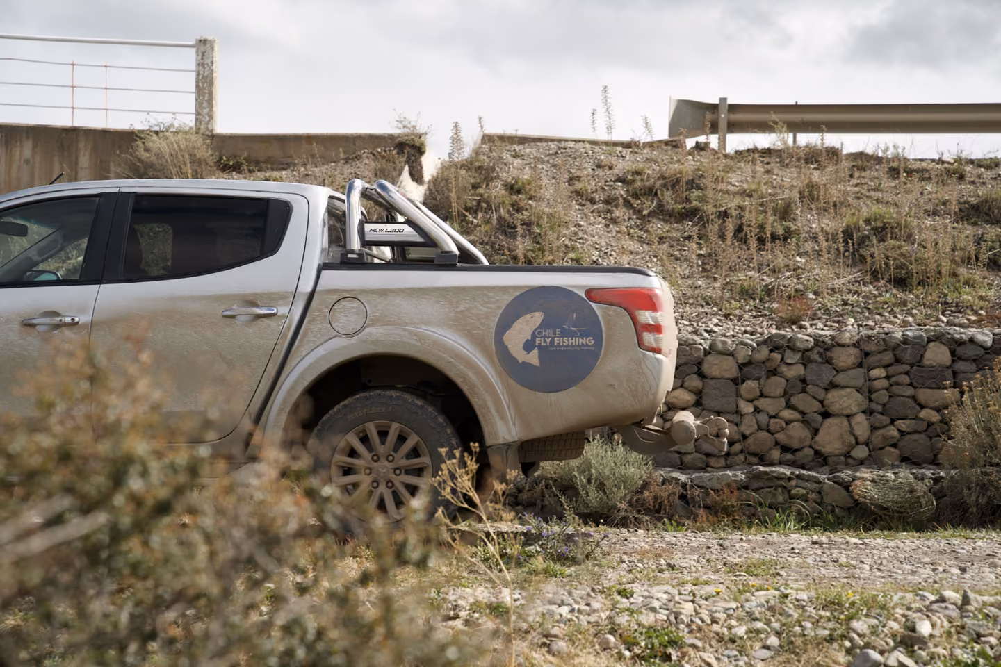 The Chile Fly Fishing 4x4 parked beside a stone wall near Coyhaique