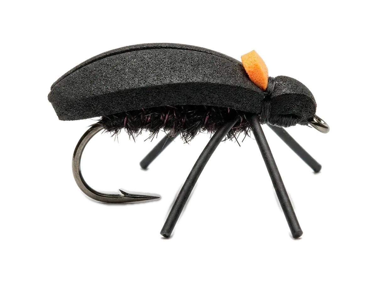 AI-generated studio render of a large black foam beetle fly with black rubber legs and an orange sight indicator, imitating the cantaria stag beetle