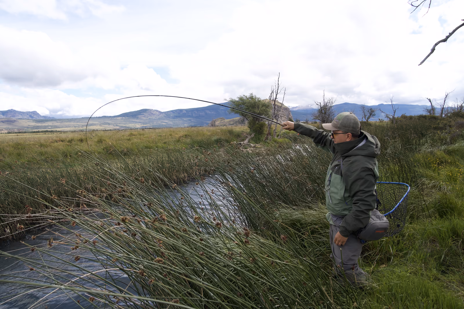 An angler casting over a spring creek near Coyhaique