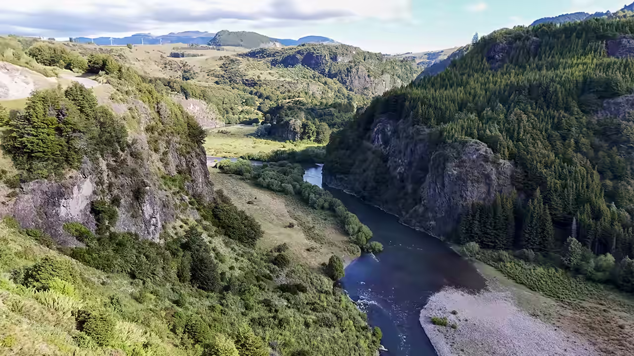 The Simpson River running through its valley between rock walls and forested slopes near Coyhaique